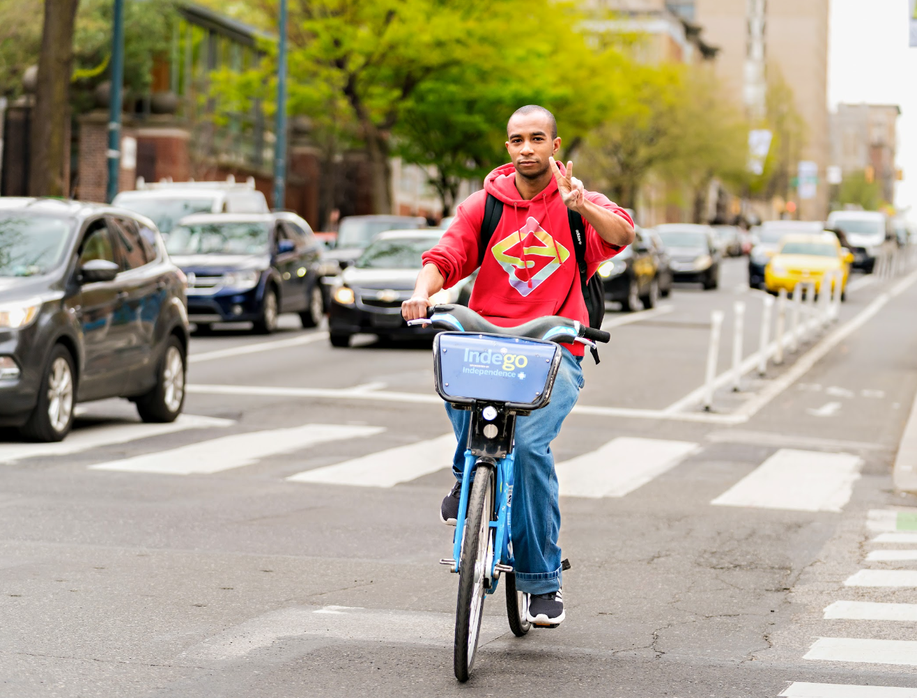 Biker on an Indego Bike holding up peace sign